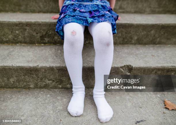 bottom half of shoeless little girl with ripped tights and dirty knees - strumpbyxor bildbanksfoton och bilder