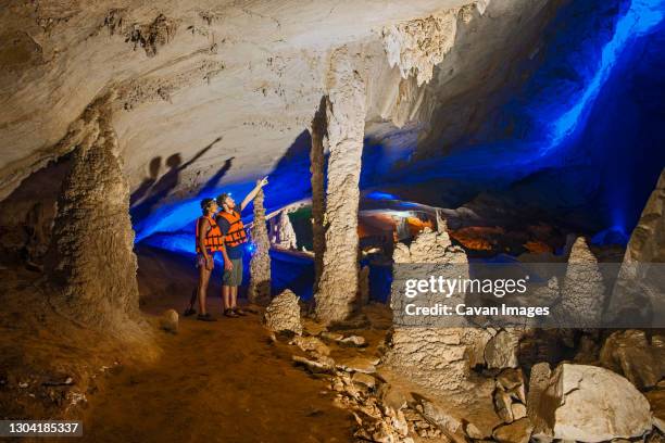 couple exploring kong lo cave in laos - flashlight-cave stock pictures, royalty-free photos & images
