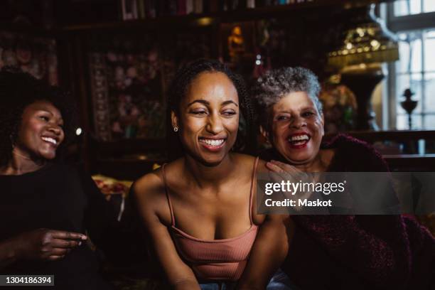 cheerful multi-generational females sitting in bedroom at apartment - grandma daughter stock pictures, royalty-free photos & images