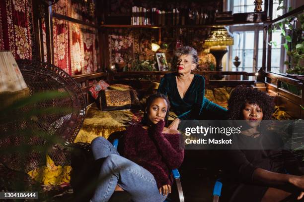 portrait of confident multi-generational females sitting in bedroom at apartment - fashionable grandma stock pictures, royalty-free photos & images