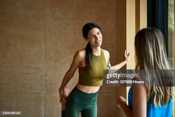 two women in conversation at yoga studio - een dag uit het leven serie stockfoto's en -beelden