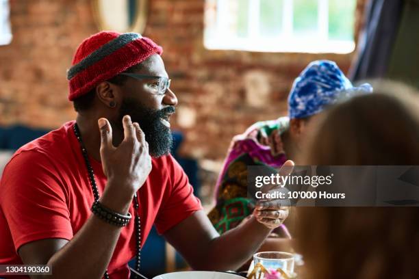 mature black man talking gesturing at lunch table - sprechen zusammen cafe stock-fotos und bilder