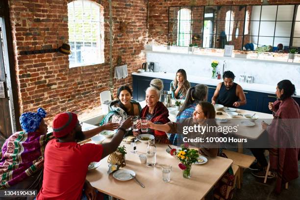 multi-ethnic friends in dining room having celebratory lunch - dining overlooking water stock pictures, royalty-free photos & images