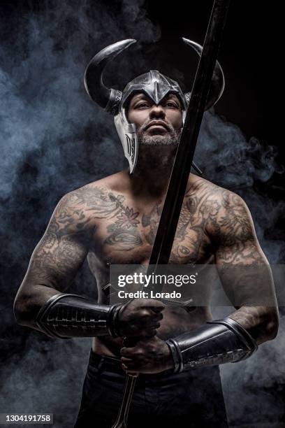 minotauro personaje fantasía hombre negro sosteniendo una espada - minotauro fotografías e imágenes de stock