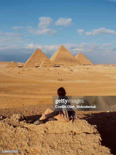 woman sitting in the desert near the giza pyramids - pyramid egypt stock pictures, royalty-free photos & images