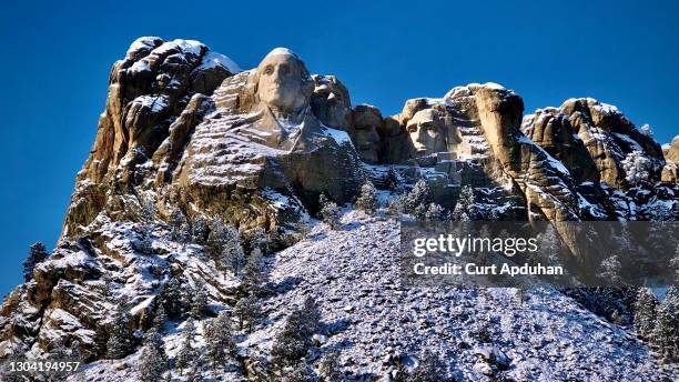 mount rushmore national memorial ~ a sunny day in winter with snow blanketing the presidents. - keystone stock pictures, royalty-free photos & images