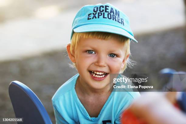 cute blond boy 3-4 y.o. playing at the playground at summer sunny day - eczema child stock-fotos und bilder