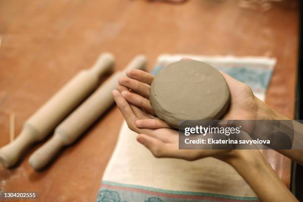 hands hold clay for modeling. close-up. top view. - artists model imagens e fotografias de stock