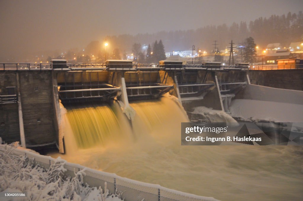 View on dam and locks on a cold winter evening with ice and snow. Houses in the back.