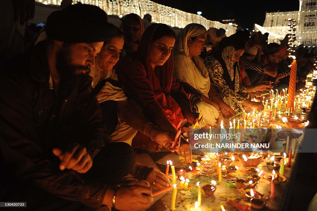 Indian Sikh devotees light candles as th