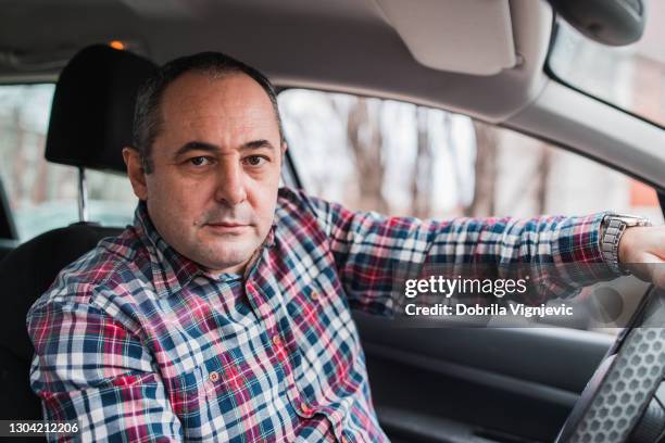 mid aged man sitting comfortably in his car - uber driver stock pictures, royalty-free photos & images