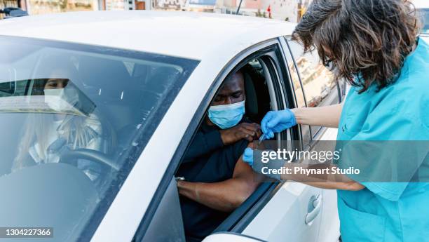 nurse performing immunization in the car - car studio shot stock pictures, royalty-free photos & images