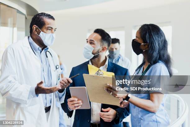 during coronavirus outbreak, healthcare professional wear protective masks - hospital leadership stock pictures, royalty-free photos & images