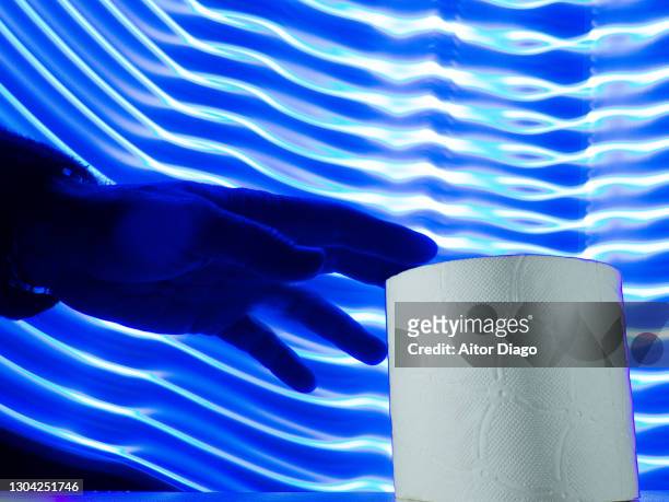 person´s hand is going to take on an toilet paper roll. futuristic blue lines in the background. - traveler's diarrhoea stock pictures, royalty-free photos & images