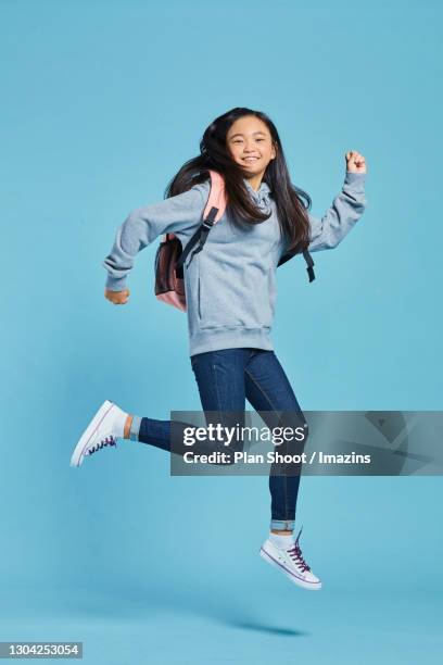 a smiling girl jumping - kids side view isolated stockfoto's en -beelden