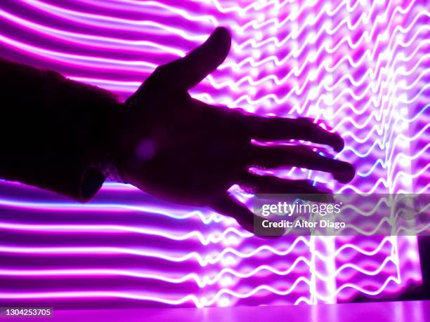 person´s hand in a futuristic background with purple lines in movement. - virtual handshake stock pictures, royalty-free photos & images