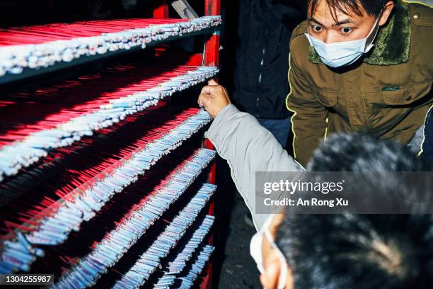 Participants lining up the fireworks in preparation to launch them. On February 26, 2021 in Tainan, Taiwan. The Yanshui Beehive Fireworks Festival is...