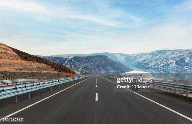 asphalt road and snowcapped mountains - empty road stock pictures, royalty-free photos & images