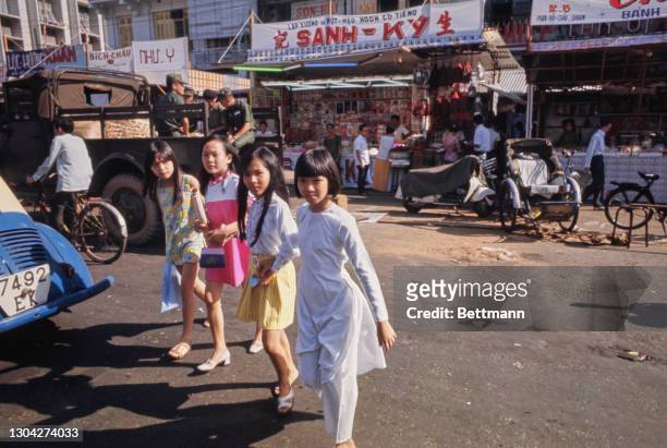 Four young Vietnamese girls join shoppers among the pre-Tet shopping rush, the Tet celebration being important to Vietnamese culture, in the central...