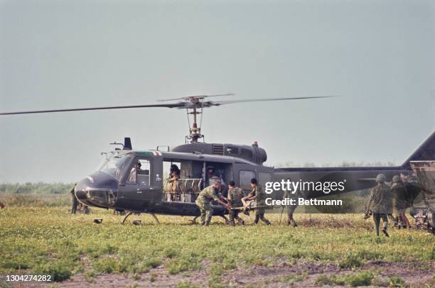 Rangers, the light infantry of the Army of the Republic of Vietnam, transporting an injured colleague on a stretcher to a Bell UH-1 Iroquois...