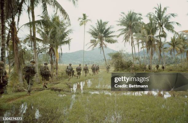 Soldiers of the United States Army's 1st Cavalry Division move through a paddy field during a search-and-destroy mission in the high ground of Qui...