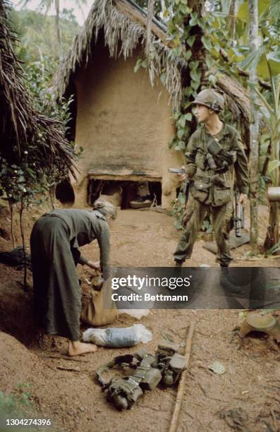 Soldier of the United States Army's 1st Cavalry Division questions a Vietnamese woman in Phu Cat, North Qui Nhon, South Vietnam, 5th January 1967....