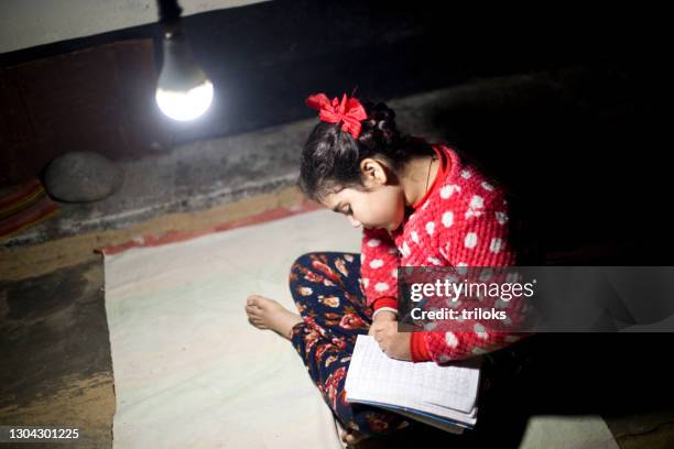 girl studying in street light at village - village girl stock pictures, royalty-free photos & images