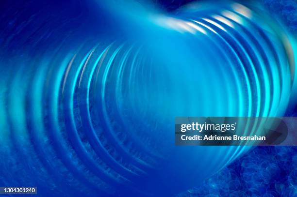 blue coil on blue background - metal coil toy stock-fotos und bilder