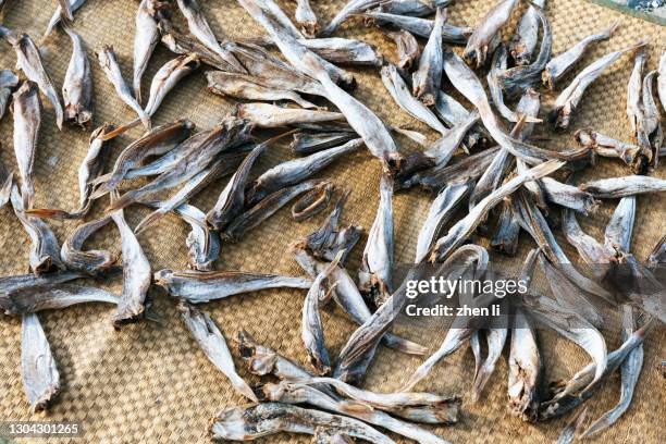 dried fish on the straw mat - dried fish stock pictures, royalty-free photos & images