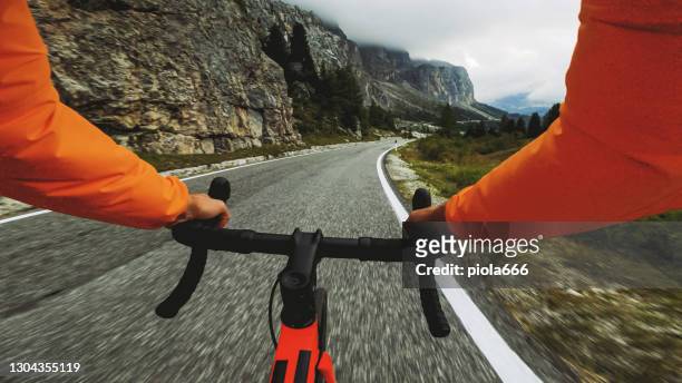pov punto de vista de carreras de bicicletas montando en una carretera en el bosque de dolomitas - manillar fotografías e imágenes de stock