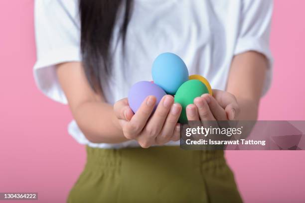 hands holding modern painted easter eggs. selective focus. toned picture - egg donation stock pictures, royalty-free photos & images