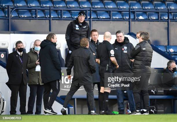Referee Lee Mason speaks with Graham Potter, Manager of Brighton and Hove Albion and Sam Allardyce, Manager of West Bromwich Albion, as a decision is...