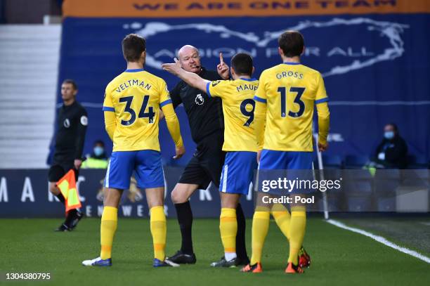 Joel Veltman, Neal Maupay, and Pascal Gross of Brighton and Hove Albion confront Referee Lee Mason as He decides to whether to award Brighton and...