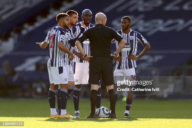 Darnell Furlong, Okay Yokuslu, Mbaye Diagne and Ainsley Maitland-Niles of West Bromwich Albion confront Referee Lee Mason as he makes changes to his...