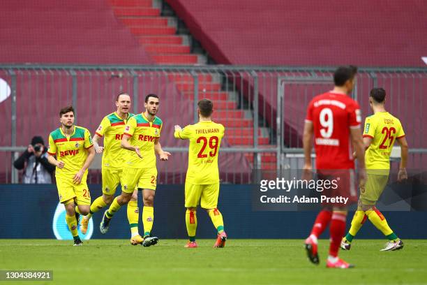 Ellyes Skhiri of 1. FC Koeln celebrates with teammate Jan Thielmann after scoring his team's first goal during the Bundesliga match between FC Bayern...