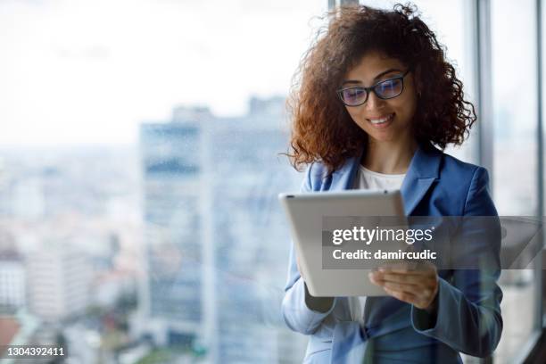 young smiling businesswoman using using digital tablet in office - accounting software stock pictures, royalty-free photos & images