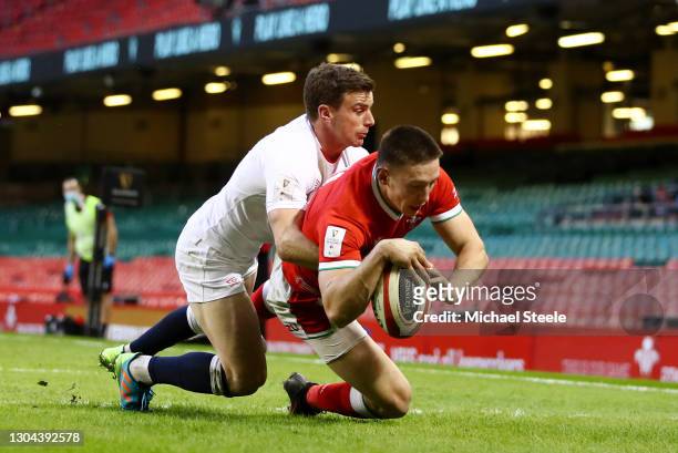 Josh Adams of Wales scores their side's first try as George Ford of England tackles during the Guinness Six Nations match between Wales and England...