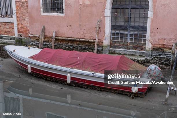 Boat is beached at low tide in a canal on February 27, 2021 in Venice, Italy. An exceptional low tide affected Venice this afternoon creating...