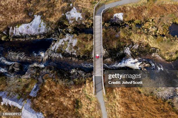 aerial view of a senior man using on a footbridge - scottish coat stock pictures, royalty-free photos & images