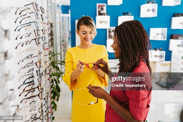 optometrist helping client to choose eyeglasses - choosing eyeglasses stock pictures, royalty-free photos & images