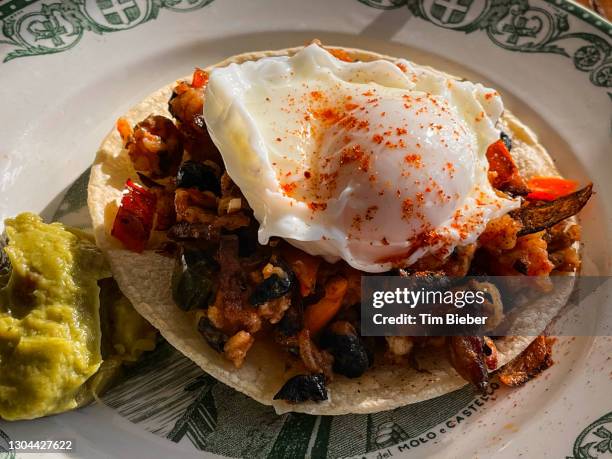 heuvos rancheros egg breakfast on tortilla with sausage, avocado and black beans - huevos-rancheros fotografías e imágenes de stock