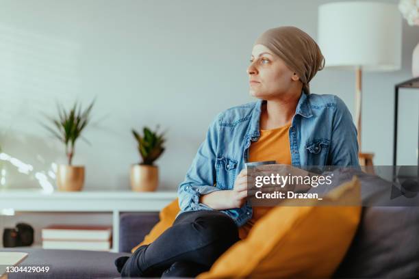 cancer patient looking far, wearing headscarf - chemotherapy stock pictures, royalty-free photos & images