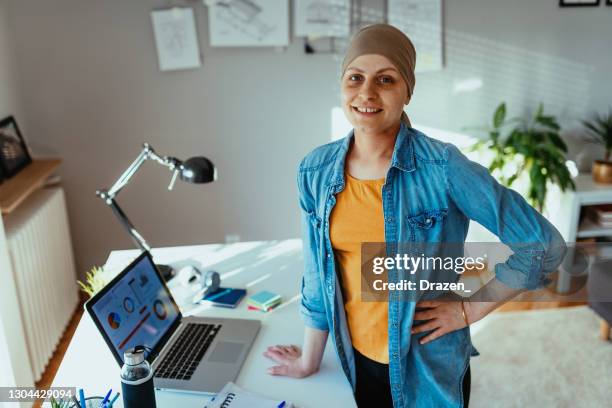 cancer patient with headscarf working in office or home office during covid-19 lockdown - leanincollection stock pictures, royalty-free photos & images