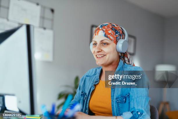 cancer patient with headscarf working in office or home office during covid-19 lockdown - lenço na cabeça enfeites para a cabeça imagens e fotografias de stock