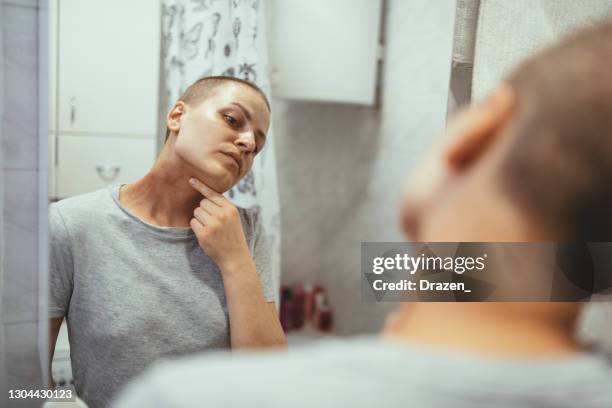 千禧年癌症患者在浴室檢查化療后的皮膚 - skin cancer face 個照片及圖片檔