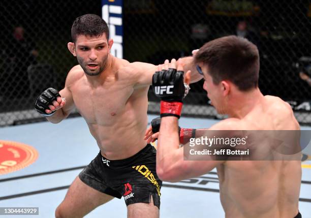 Thiago Moises of Brazil punches Alexander Hernandez in a lightweight bout during the UFC Fight Night event at UFC APEX on February 27, 2021 in Las...