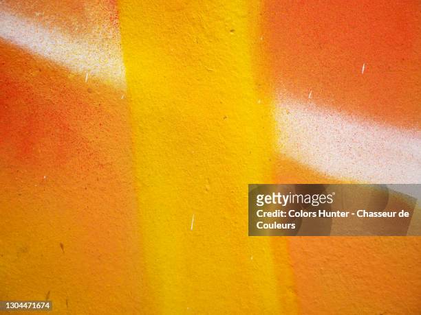 vivid yellow and orange spray paints on a clean wall in paris - graffiti ストックフォトと画像