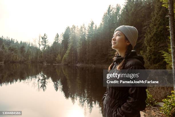 giovane donna multietnica in tranquilla contemplazione ai margini del lago - asian landscape foto e immagini stock