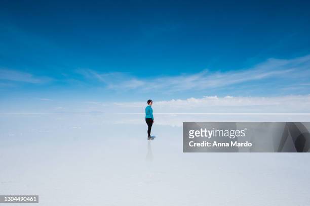 girl looking into the distance at salar de uyuni - cloud sales fotografías e imágenes de stock
