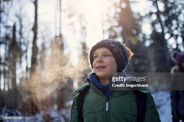 portrait of little boy hiking in beautiful winter forest. - breath vapor stock pictures, royalty-free photos & images